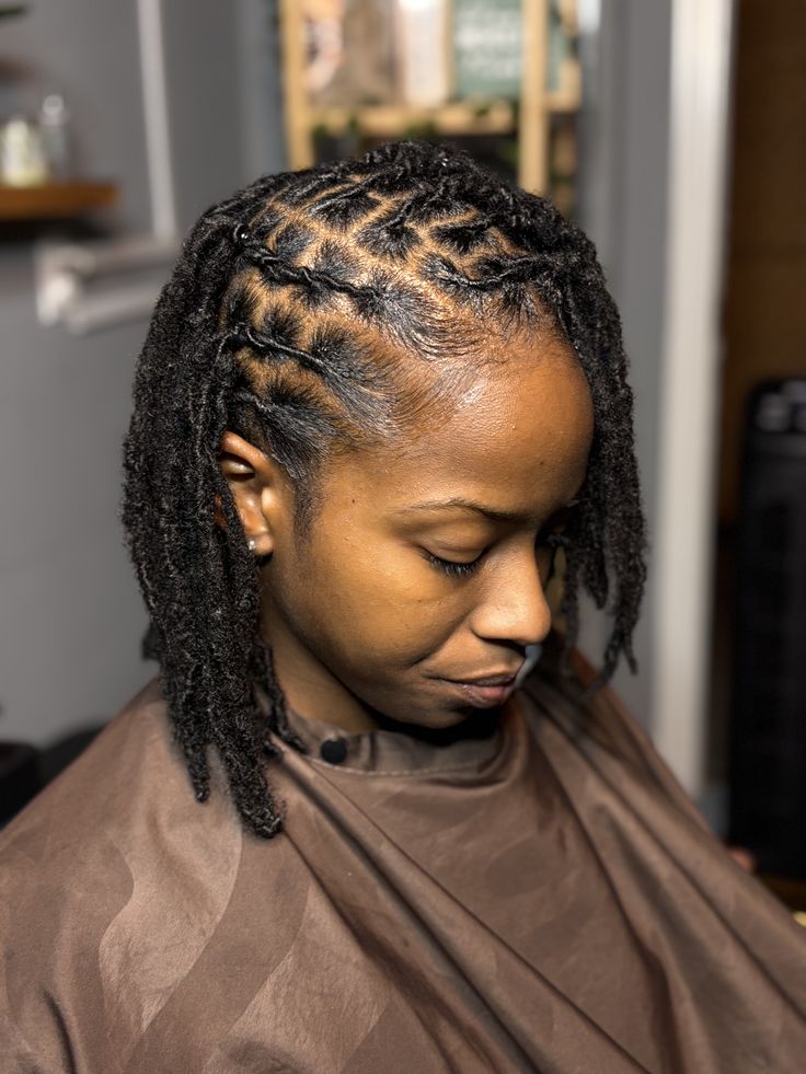 Stylist installing locs for a client in the chair