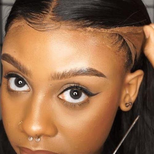 Lace front being lifted away from the hairline at the temple